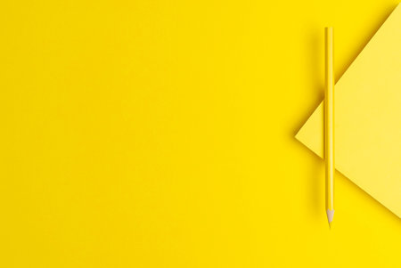 Minimalist Yellow Background with Pencil and Geometric Shapes for Creativity and Designの写真素材