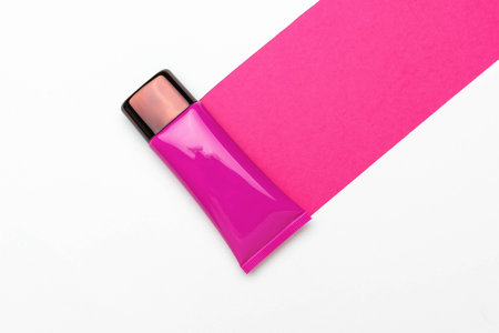 Pink Cosmetic Tube on White Background with Vivid Pink Strip - Minimalist Beauty Product Imageの写真素材