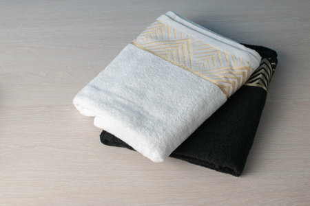 Folded White and Black Towels with Geometric Patterns on Wooden Tableの写真素材