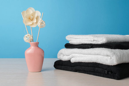 Spa Aromatherapy Still Life with Towels and Decorative Flower Arrangements Against Blue Backgroundの写真素材