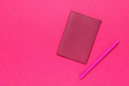 Pink Leather Wallet and Pen on Pink Background - Vibrant Minimalist Still Lifeの写真素材