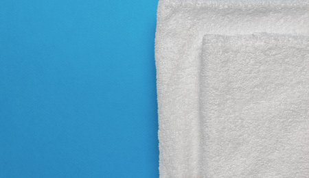 ** Soft White Towels on Blue Background - Minimalist Clean Linen Flat Lay for Home and Beauty Spa Conceptの写真素材