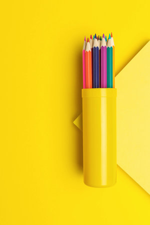 Colorful Pencils in Yellow Holder with Geometric Background Creative Art Suppliesの写真素材