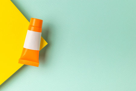 Orange Tube with Blank Label on Yellow and Mint Background Perfect for Product Mockup and Brandingの写真素材