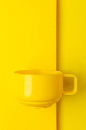 Bright Yellow Mug against Minimalist Monochrome Background for Creative Design and Advertisingの写真素材