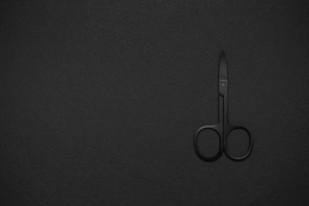 Minimalist Black Scissors on Dark Background for Sleek and Modern Designの写真素材
