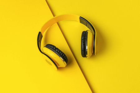 Yellow Wireless Headphones on Bright Yellow Background for Music and Technology Themes