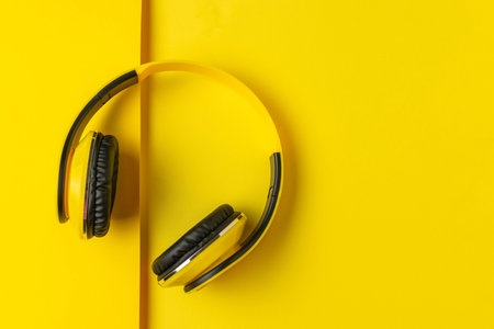 Yellow Headphones on Bright Yellow Background - Modern and Vibrant Audio Technology Conceptの写真素材