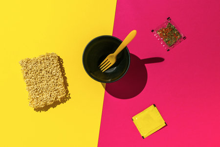 Instant Noodle Preparation on Bright Yellow and Pink Split Backgroundの写真素材