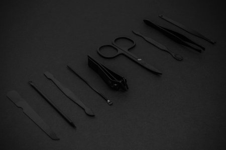 Black Stainless Steel Nail and Cuticle Care Tools on Dark Backgroundの写真素材