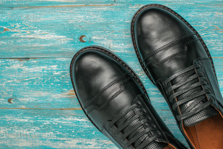 Top View of Stylish Black Leather Shoes on Distressed Turquoise Wooden Backgroundの写真素材