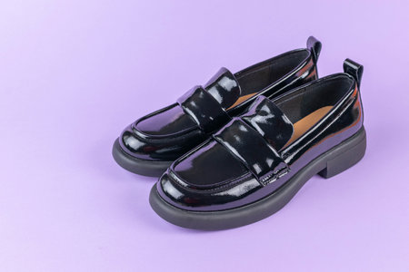Stylish Black Patent Leather Loafers on Purple Background - Modern Fashion Footwearの写真素材