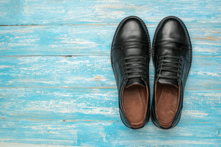 Polished Black Leather Shoes on Weathered Blue Wooden Backgroundの写真素材