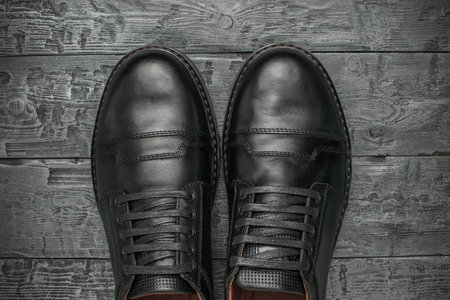 Top View of Black Formal Leather Shoes on Wooden Floor Backgroundの写真素材