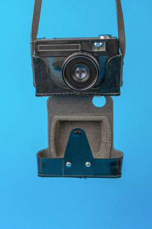 Vintage Camera with Leather Case Hanging on Blue Backgroundの写真素材