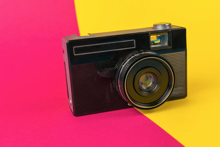 Vintage Film Camera on Colorful Pink and Yellow Backgroundの写真素材