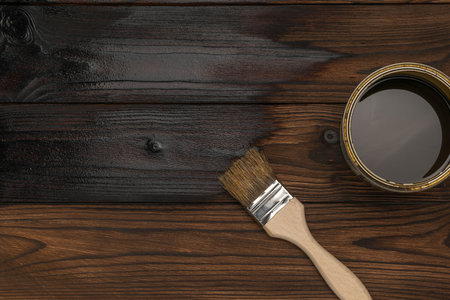 Wood Stain Application on Wooden Planks with Paintbrush and Can of Stain - DIY Home Improvementの写真素材