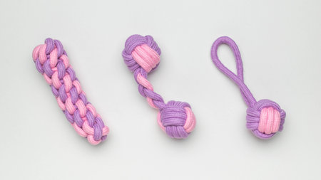 Pastel Pink and Purple Handmade Rope Dog Toys on Light Backgroundの写真素材