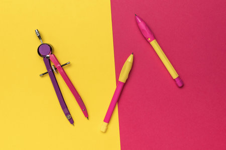 Colorful Stationery on Vibrant Background - Compasses and Pencils for School and Office Suppliesの写真素材