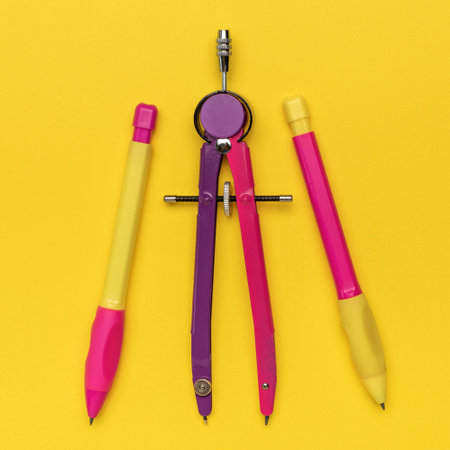 Colorful Set of School Supplies with Compasses Against Yellow Backgroundの写真素材