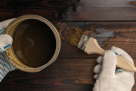 Hands Staining Wooden Surface with Brush and Brown Wood Stain for Home Improvement Projectの写真素材