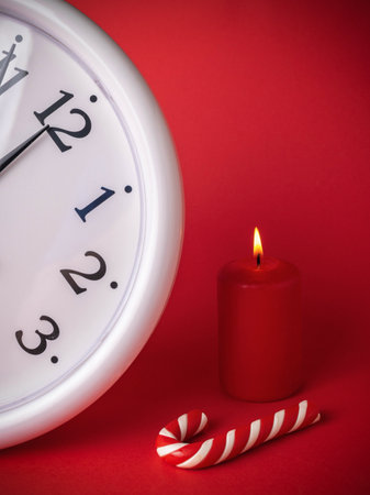 Red Themed Christmas Scene with Clock, Candle, and Candy Caneの写真素材