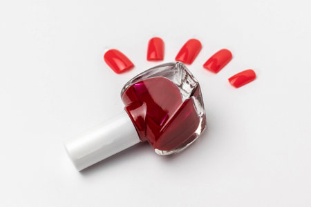 Red Nail Polish with Matching Press-On Nails on White Backgroundの写真素材