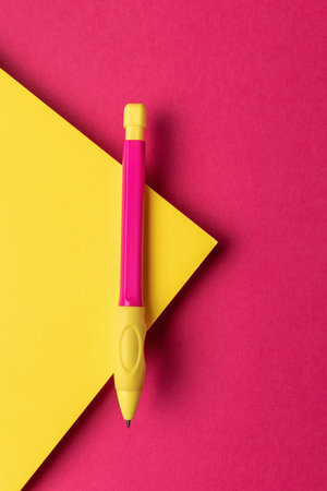 Colorful Ballpoint Pen on Bright Pink and Yellow Geometric Backgroundの写真素材