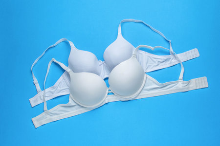 Set of White Bras Arranged on Blue Background - Intimate Apparel for Womenの写真素材