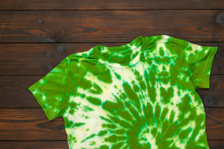 Green and White Tie-Dye T-Shirt on Wooden Background - Vibrant Fashion Apparelの写真素材