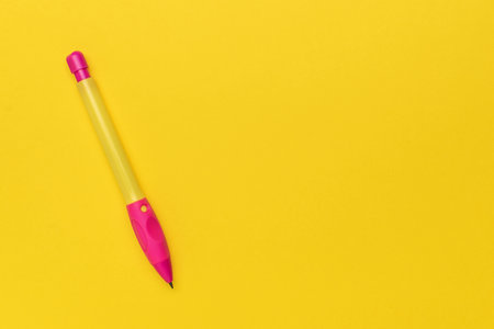 Bright Yellow Background with Pink and Yellow Pen for Creative Writing and Office Useの写真素材