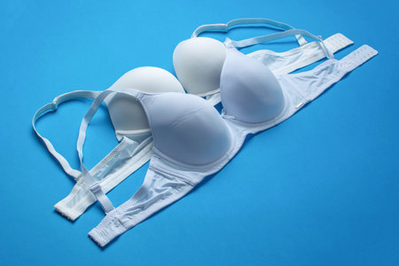 Set of White and Light Blue Bras on Blue Background Womens Lingerie, Intimate Apparel, Fashion Accessoriesの写真素材