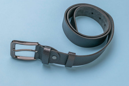 Stylish Black Leather Belt with Silver Buckle on Blue Background - Fashion Accessoryの写真素材