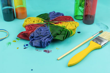 Colorful Tie-Dye T-Shirt Creation with Dye Bottles and Brush on Blue Backgroundの写真素材
