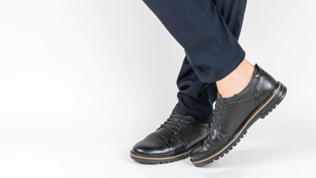Businessman Wearing Black Leather Shoes and Navy Pants, White Background, Close-Up, Professional Attireの写真素材