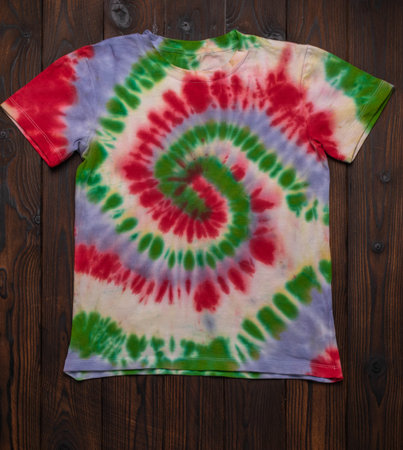 Colorful Tie-Dye T-Shirt on Dark Wooden Backgroundの写真素材