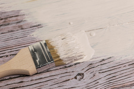 Painting Wooden Surface with White Paint Using a Brushの写真素材