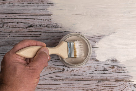 Hand Painting Wooden Surface with White Paint Using Brushの写真素材