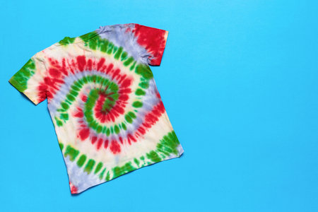 Vibrant Tie-Dye T-Shirt on Bright Blue Background: Fashion, Colorful Patterns, and Creative Artistry in Stock Photographyの写真素材