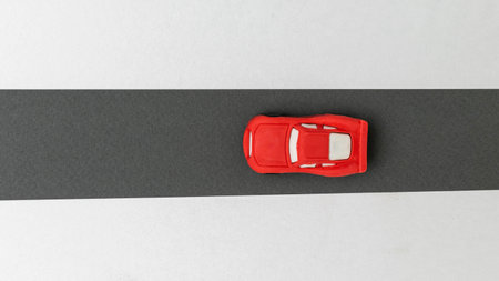 Minimalist Red Toy Car on Black and White Background: Symbolizing Simplicity and Speed in Modern Designの写真素材