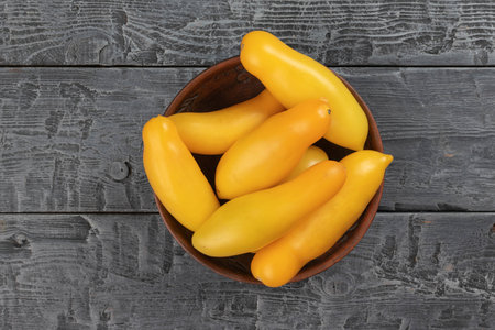 Fresh Organic Yellow Zucchini in a Wooden Bowl on Rustic Gray Wooden Backgroundの写真素材