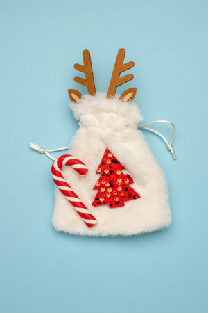 Festive Christmas Bag with Candy Cane and Reindeer Design on Blue Backgroundの写真素材