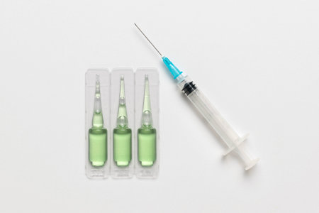 Medical Injection: Green Ampoules and Syringe on White Background for Healthcare Conceptsの写真素材