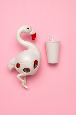 Playful Flamingo and Miniature Drink on Pink Background: Whimsical Summer Vibesの写真素材