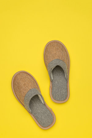 Cozy Woven Home Slippers on Vibrant Yellow Backgroundの写真素材