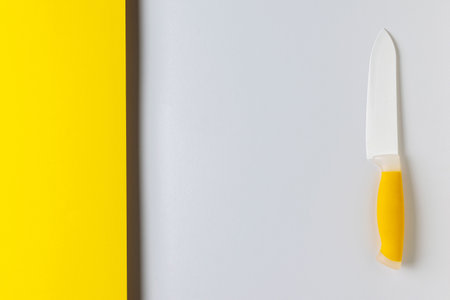 Modern Minimalist Kitchen Knife on Yellow and Gray Background with Sleek Designの写真素材