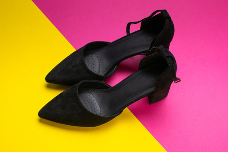 Stylish Black Shoes on Vibrant Pink and Yellow Background - Fashion Footwear Photographyの写真素材