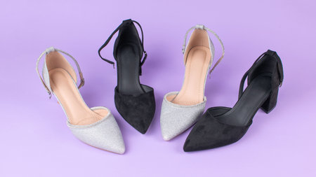 Elegant Women's High Heel Shoes in Black and Silver on Purple Backgroundの写真素材