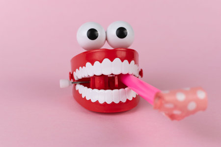 Funny Wind-Up Chattering Teeth Toy with Googly Eyes on Pink Background