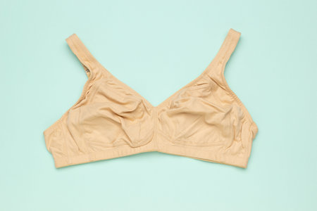 Beige Bra on Pastel Green Background: Minimalist Fashion and Underwear Designの写真素材